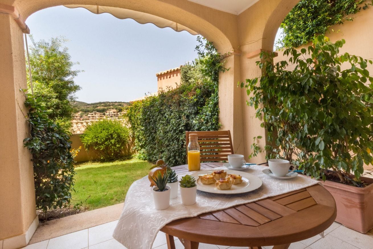 A table set for breakfast with a view of a hillside.
