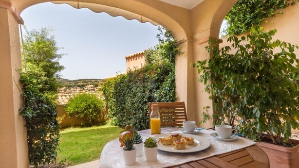 A table set for breakfast with a view of a hillside.