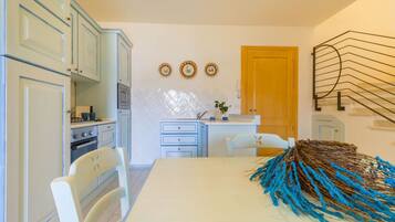 A kitchen with light blue cabinets, a wooden door, and a decorative wall piece.