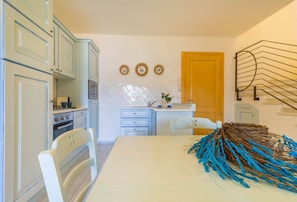 Una cocina con armarios azul claro, una puerta de madera y un adorno decorativo en la pared.