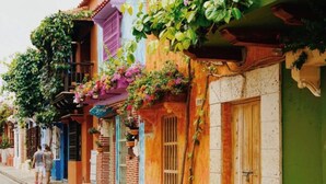 A colorful street with buildings adorned with plants and flowers. - Excellent Apartment With the Best Location in the City (Cali)