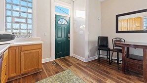 A kitchen with wooden cabinets, a microwave, and a window. - Indy Stadium Villas 707 (Indianapolis)