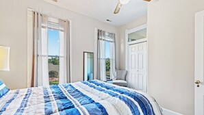 A bedroom with a large bed, a chair, and a door. - Indy Stadium Villas 707 (Indianapolis)