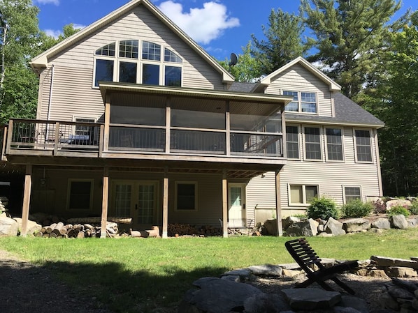 A two-story house with a balcony, a covered porch, and a stone fireplace. - We now have heat pump...like A/C!! Lakefront, mountain biking and hiking trails! (Holden)