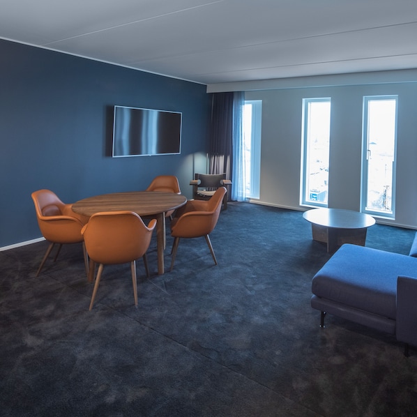 A modern meeting room with a large table, six chairs, a flat-screen TV, and large windows. - Comwell Copenhagen Portside Dolce by Wyndham (Copenhagen)