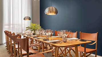 A conference room with a long table set for a meeting, surrounded by leather chairs.
