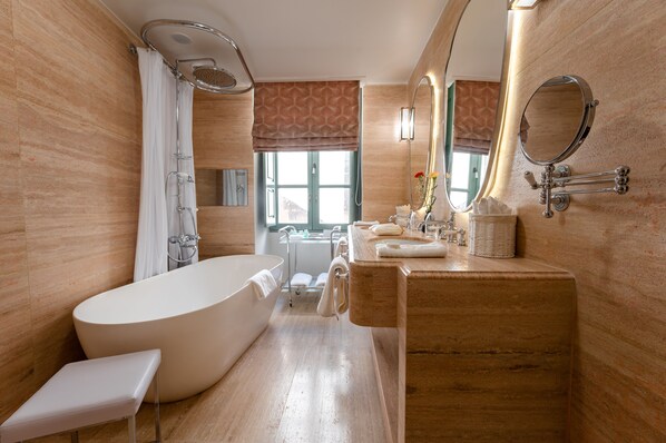 Un baño moderno con una bañera independiente, un tocador con espejo y una zona de ducha.