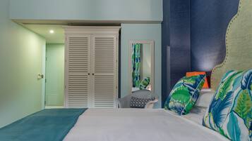 A bedroom with a bed, a chair, a wardrobe, and a mirror.