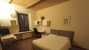 A bedroom with a bed, desk, chair, and a window. - Questa elegante villa offre camere perfetto per viaggi di lavoro o di coppia (Carpi)