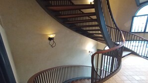 A spiral staircase with wooden steps and metal railings, leading to an upper floor. - Questa elegante villa offre camere perfetto per viaggi di lavoro o di coppia (Carpi)