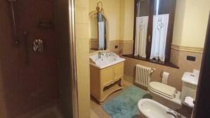 A bathroom with a shower, sink, toilet, and a window with curtains. - Questa elegante villa offre camere perfetto per viaggi di lavoro o di coppia (Carpi)