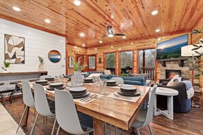 A spacious dining area with a wooden table set for four, surrounded by modern chairs. - Heated In-Cabin Pool~Theatre~Game Room~Views (Sevierville)