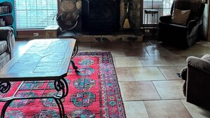 Una sala de estar acogedora con chimenea de piedra, televisor de pantalla plana y asientos cómodos.