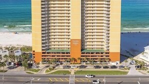 A high-rise hotel with multiple balconies, a parking garage, and a beach view. - LUXURY 20TH FLOOR BEACHFRONT CONDO/HUGE BALCONY/BEACH SERVICE/5 STAR REVIEWS (Panama City Beach)