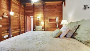 Une pièce en bois avec un lit, une chaise et une lampe.