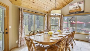 Enjoy meals with family and friends in this spacious dining area, surrounded by large windows offering views of the surrounding forest.