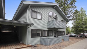 A two-story house with a balcony, a garage, and a driveway. - Powder Village E2 (Bend)