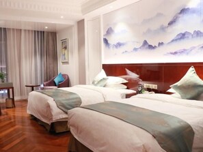 Una habitación de hotel con dos camas, un escritorio y una silla.