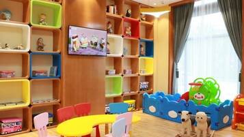 A children's playroom with colorful storage units, a television, and a play area with a slide and toys.