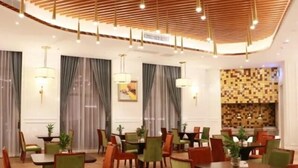 A hotel dining area with multiple tables and chairs, wooden ceiling with hanging lights, and a patterned wall in the background. - Greentree Eastern Yancheng Binhai County Aobaolia Beichen Hotel (Yancheng)