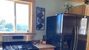 Een moderne keuken met roestvrijstalen apparatuur, houten kasten en een raam dat voor natuurlijk licht zorgt.