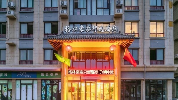 A hotel entrance with a traditional Chinese architectural style, featuring a tiled roof and a sign in Chinese characters. - Greentree Inn Qufu High Speed Railway Station (Jining)