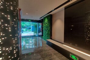 A corridor with a reflective floor, a green wall, and a large window. - Shangyuan Chain Hotel Guangzhou Railway Station (Guangzhou)