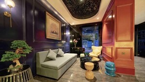 A modern interior with a sofa, a round table, a small tree, and a unique ceiling design. - Shangyuan Chain Hotel Guangzhou Railway Station (Guangzhou)