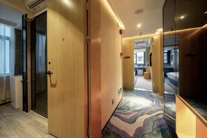 A hotel corridor with wooden doors, a patterned carpet, and a view into a room with a bed and a desk. - Shangyuan Chain Hotel Guangzhou Railway Station (Guangzhou)