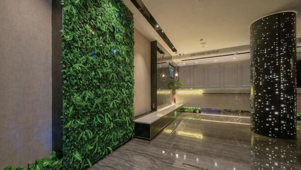 A lobby with a green vertical garden, a marble floor, and a modern reception desk. - Shangyuan Chain Hotel Guangzhou Railway Station (Guangzhou)