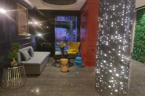 A modern living room with a sofa, armchairs, a coffee table, and decorative items. - Shangyuan Chain Hotel Guangzhou Railway Station (Guangzhou)