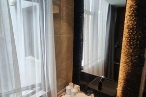 A bathroom with a large mirror, a sink, and a window with sheer curtains. - Shangyuan Chain Hotel Guangzhou Railway Station (Guangzhou)