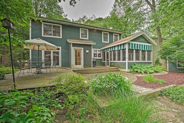 A two-story house with a deck, a covered porch, and a garden area. - Upscale Family Retreat w/ Fire Pit, Walk to Beach! (Union Pier)