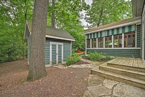 A wooden deck leading to a house with a stone pathway and a large tree. - Upscale Family Retreat w/ Fire Pit, Walk to Beach! (Union Pier)