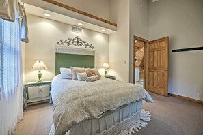 A bedroom with a large bed, two bedside tables with lamps, a decorative headboard, and a wooden wardrobe. - Upscale Family Retreat w/ Fire Pit, Walk to Beach! (Union Pier)