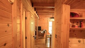 A wooden interior with a laundry area, a dining table, and chairs. - Gorgeous, tree top views from this cabin (Stanton)