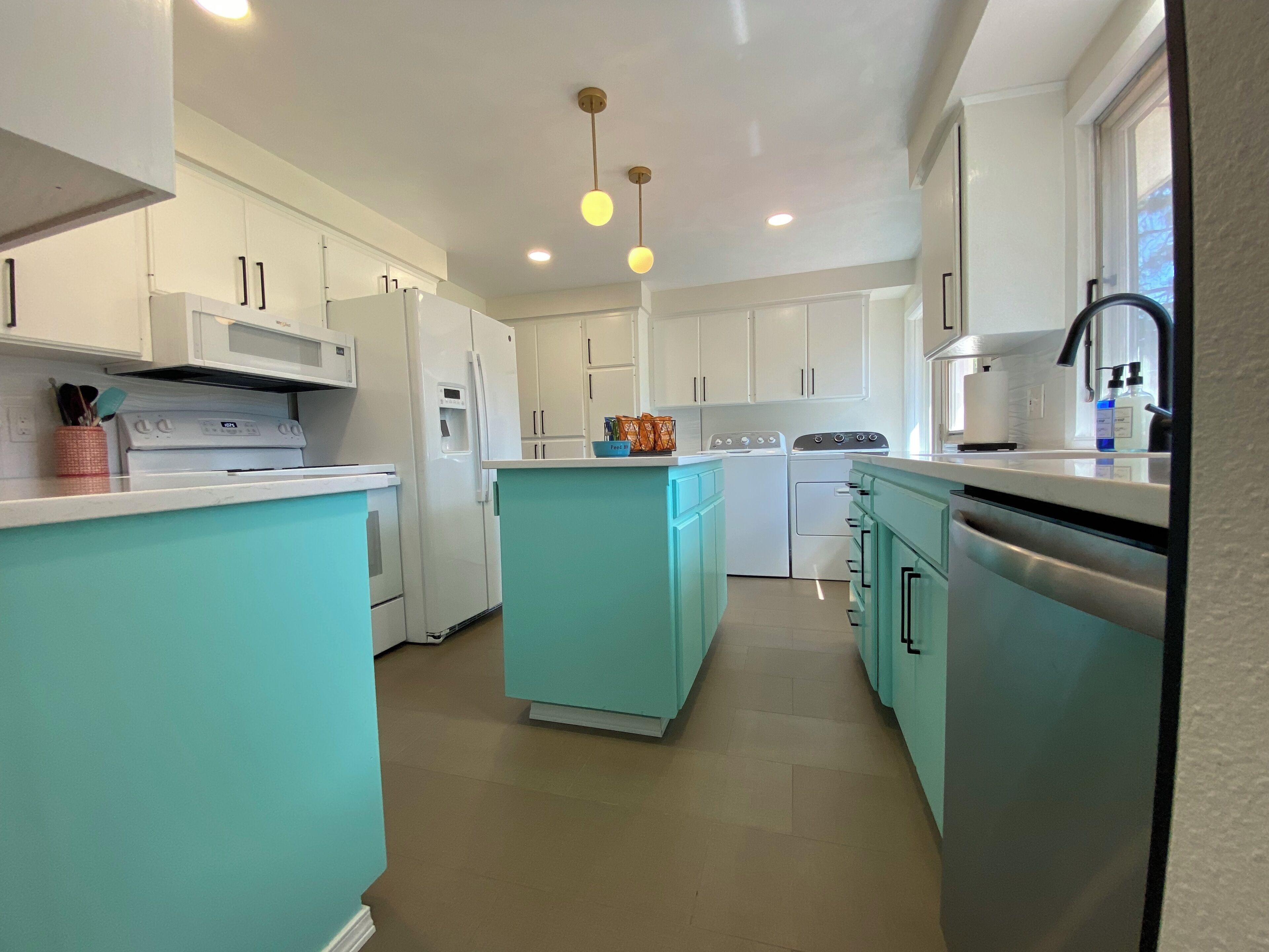 A kitchen with white cabinets, a central island, and a sink.