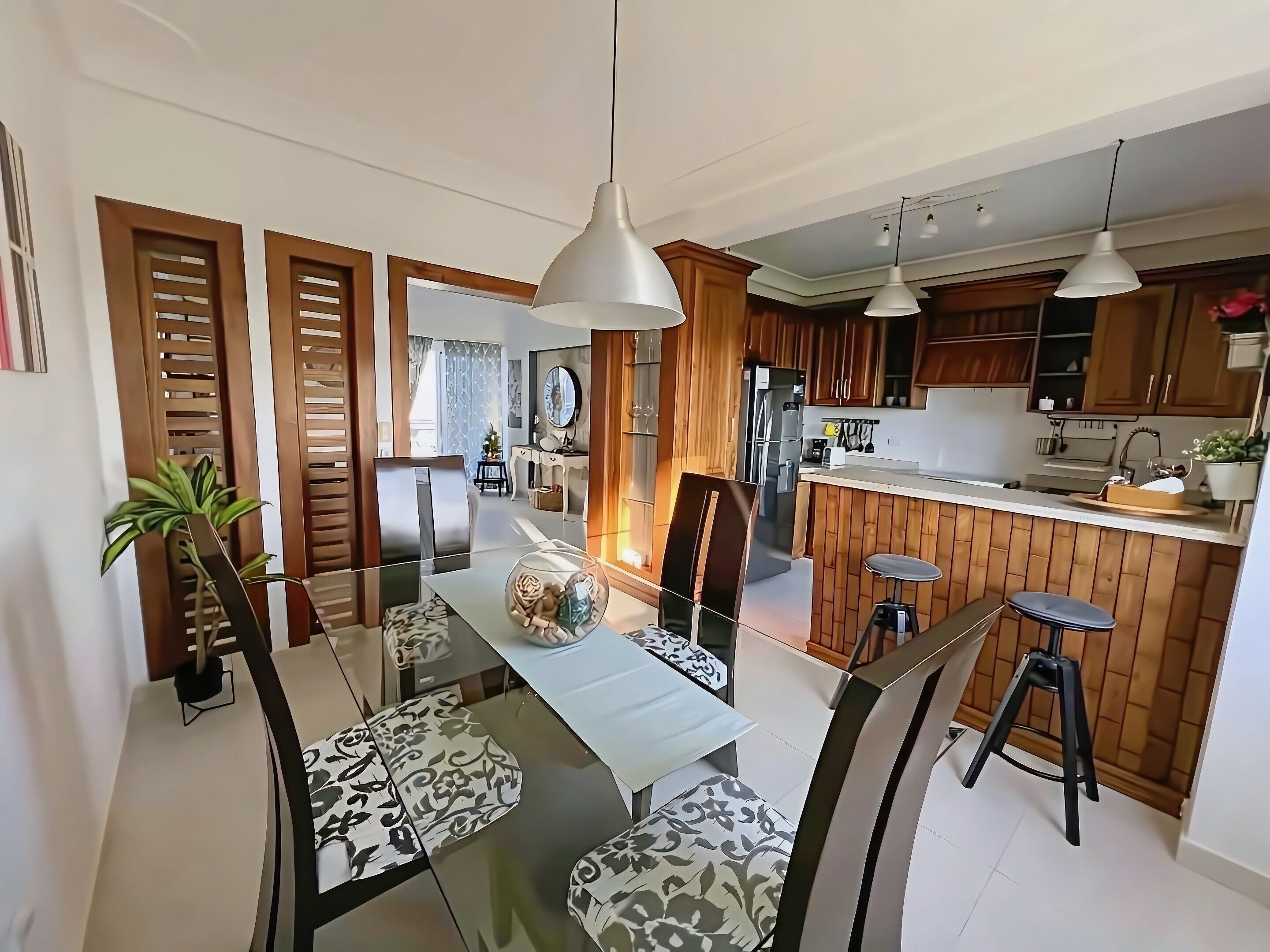 Una cocina moderna con armarios de madera, una isla central e iluminación colgante.