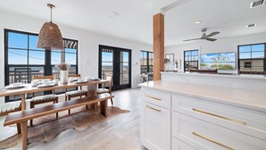 Una cocina moderna con comedor, ventanas amplias y vistas al exterior.
