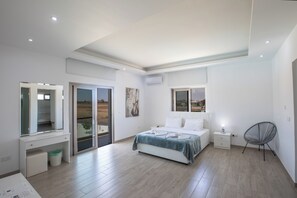 A bedroom with a bed, a desk, a chair, and a view through a glass door. - Villa Sienna, Fabulous 6bdr Protaras Villa (Paralimni)