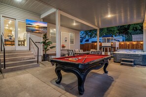 An outdoor pool area with a pool table, seating, and a hot tub. - Private heated pool/hot tub, pickleball mini golf. 9 Bdrms. 4 bath. EV charger. (La Verkin)