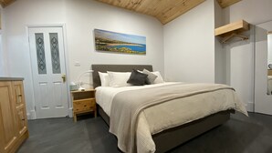 Une chambre à coucher avec un lit, une table de chevet, une lampe et un tableau au mur.