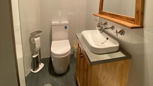 Une petite salle de bain comprenant des toilettes, un lavabo et un miroir.