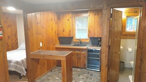 Una cocina funcional con armarios de madera, un lavamanos y un lavavajillas.