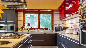 Una cocina moderna con una isla central, electrodomésticos de acero inoxidable y una pared de acento roja.