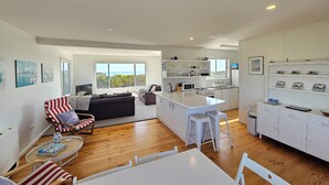 A modern apartment with a kitchen, dining area, and a living room with a large window overlooking a scenic view. - Kalimna - 360 degree ocean and marina views! (Robe)