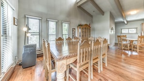 A spacious dining area with a large wooden table and chairs, a built-in cabinet, and a ceiling fan. - Spacious Ruidoso Retreat: Game Room & Pool Access! (Ruidoso)