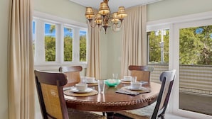 A dining area with a round table, four chairs, a chandelier, and large windows with curtains. - **SET SAIL @ COCONUT MALLORY** Condo + Last Key White Glove Service... (Key West)