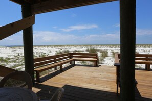 A wooden deck with benches overlooking a sandy beach with sparse vegetation. - Gulf Front, Newly Renovated ~ One More Time Again (Mexico Beach)