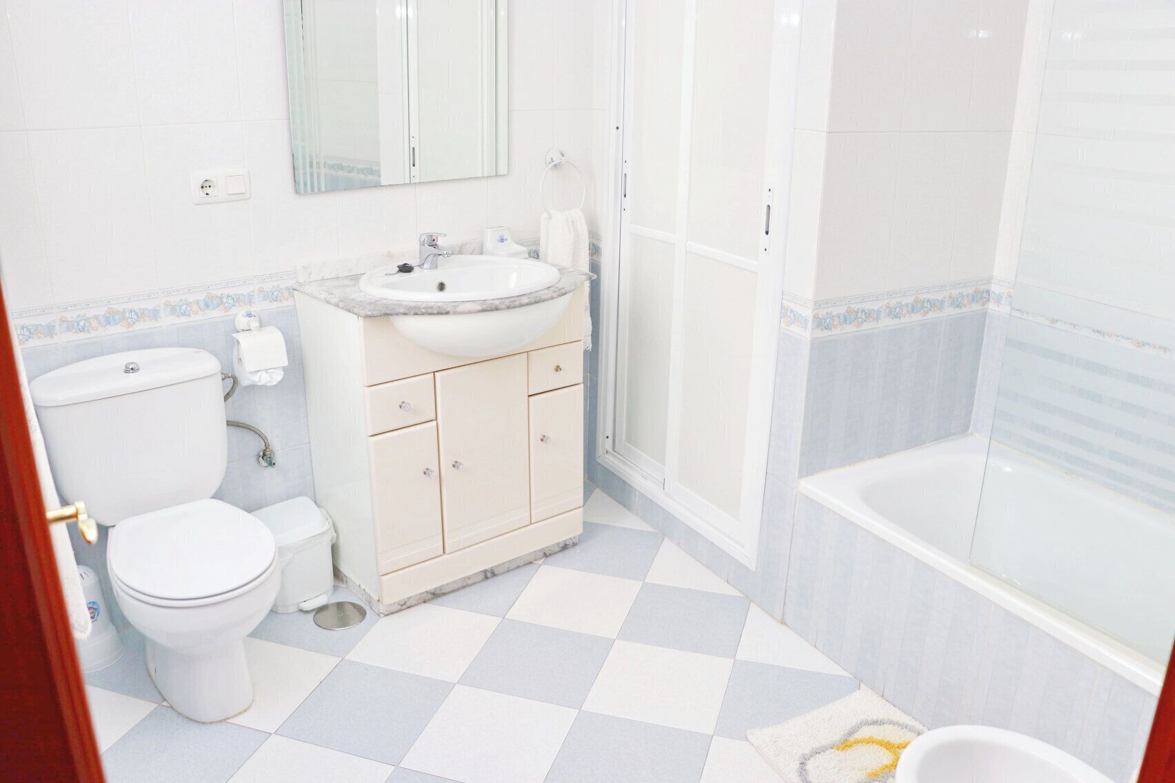 A bathroom with a toilet, sink, and bathtub.